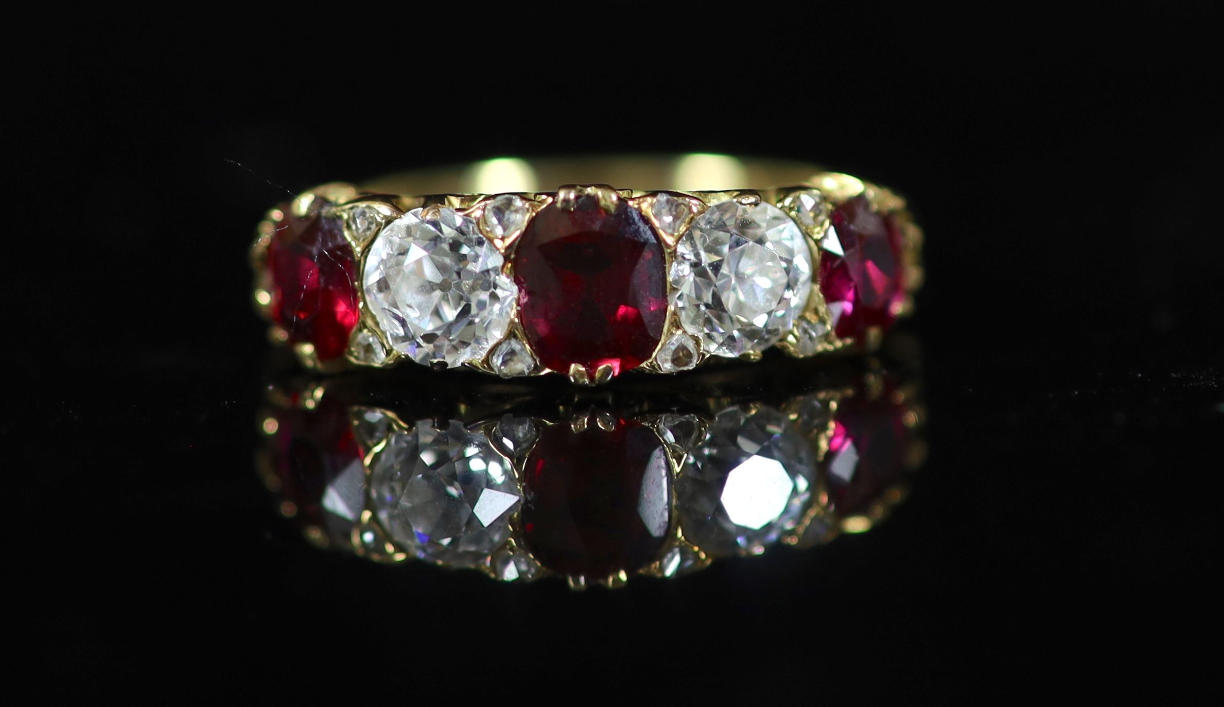 A Victorian style gold, three stone ruby and two stone diamond set half hoop ring